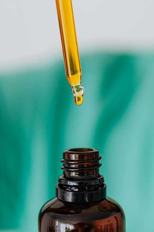 brown jar with dropper with amber colored liquid inside