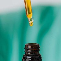 brown jar with dropper with amber colored liquid inside